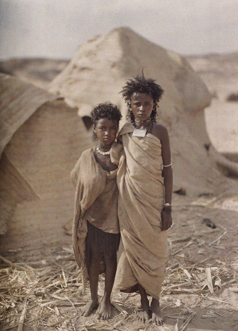 فتاتان من بشارى واقفتان أمام منازلهما في أسوان في مصر في شتاء 1914.